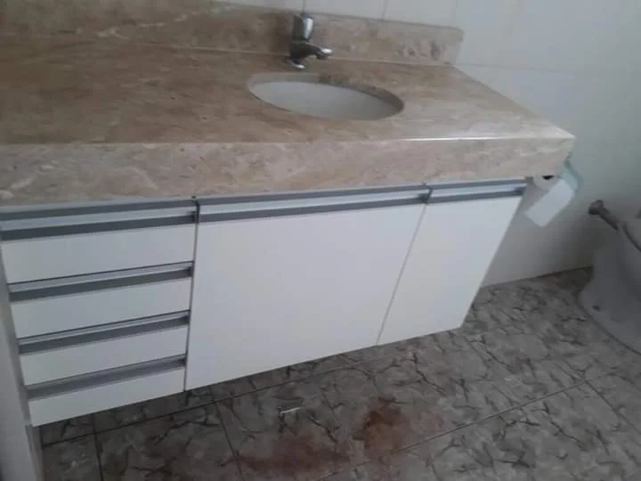 Banheiro com gabinete em madeira e cuba