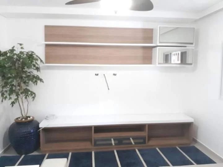 Sala com painel ripado e TV embutida